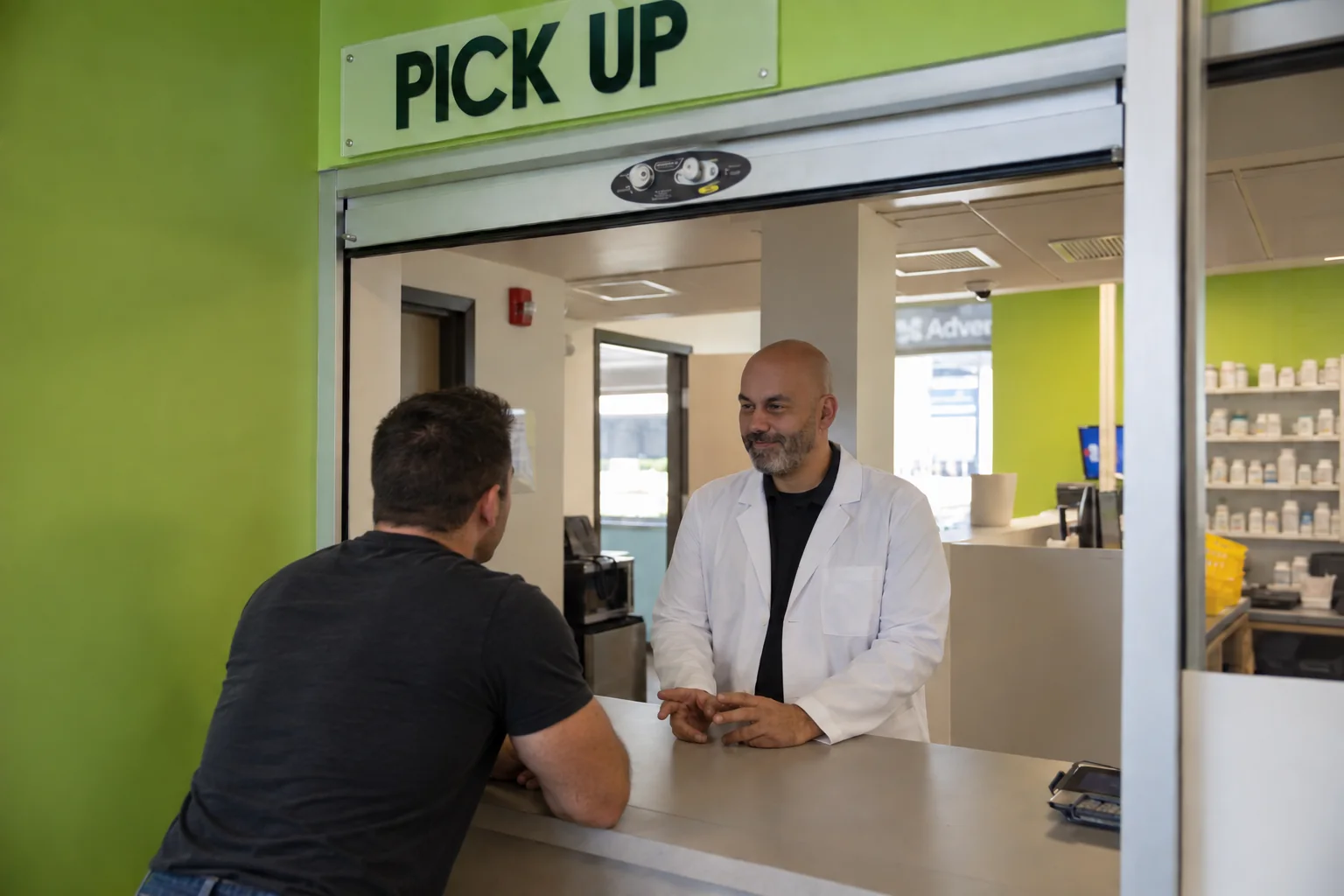 Efren, our pharmacist, handing a prescription to a patient at the pick-up window