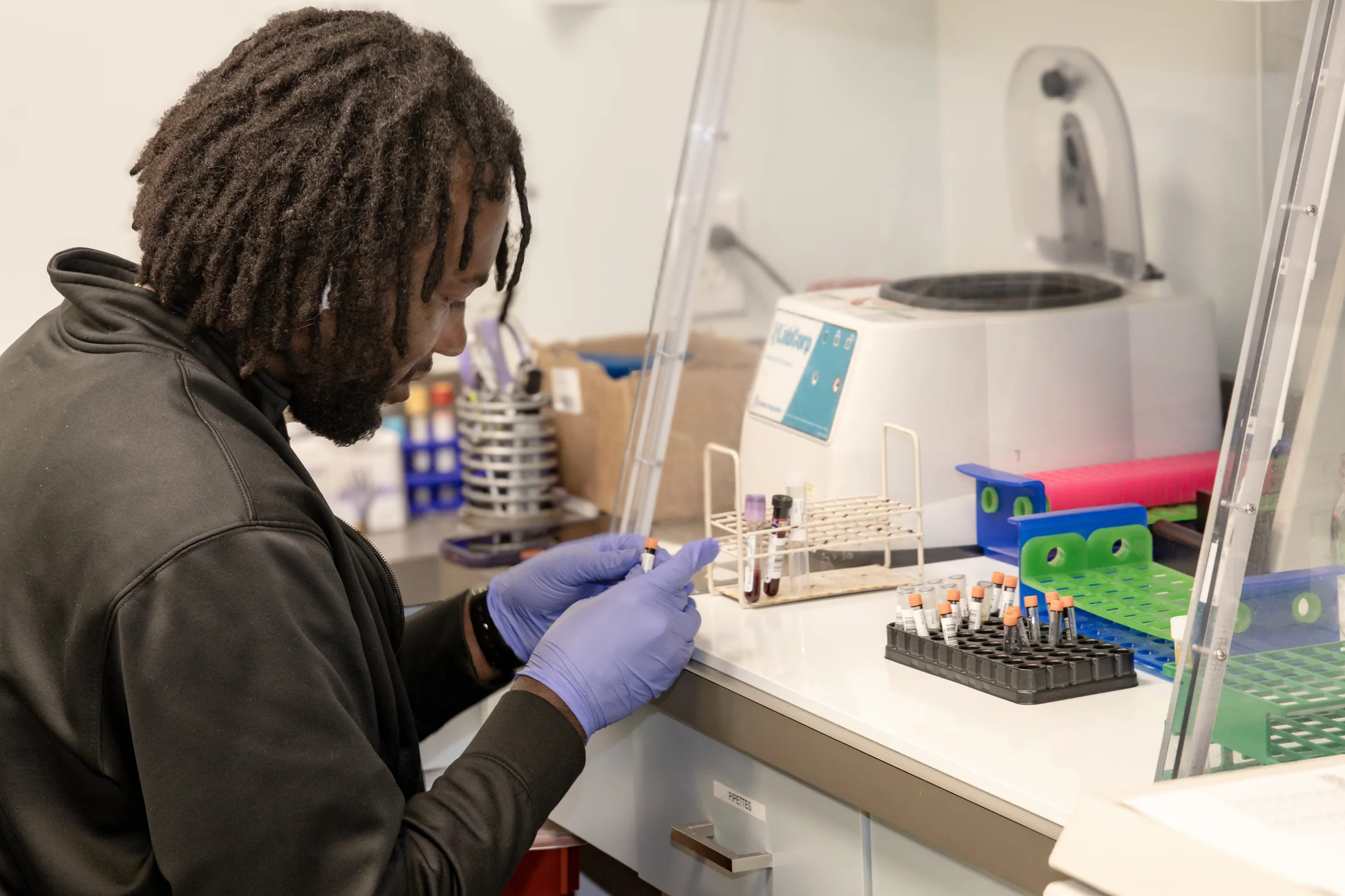 A research lab technician handling blood samples at Orlando Immunology Center
